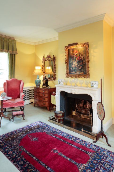 A MAHOGANY WING ARMCHAIR IN QUEEN ANNE STYLE