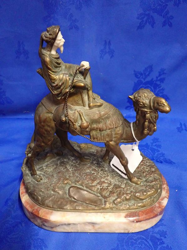 A BRONZE AND IVORY FIGURE OF A MIDDLE EASTERN MAN RIDING ON A CAMEL