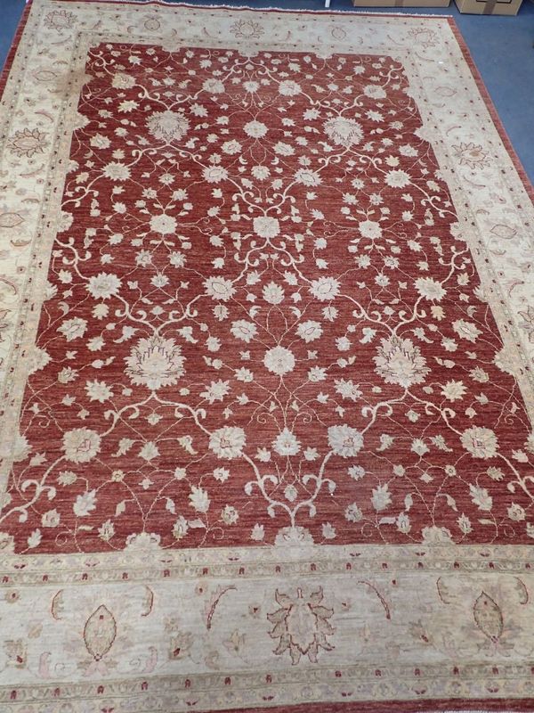 A LARGE RED GROUND PERSIAN DESIGN RUG