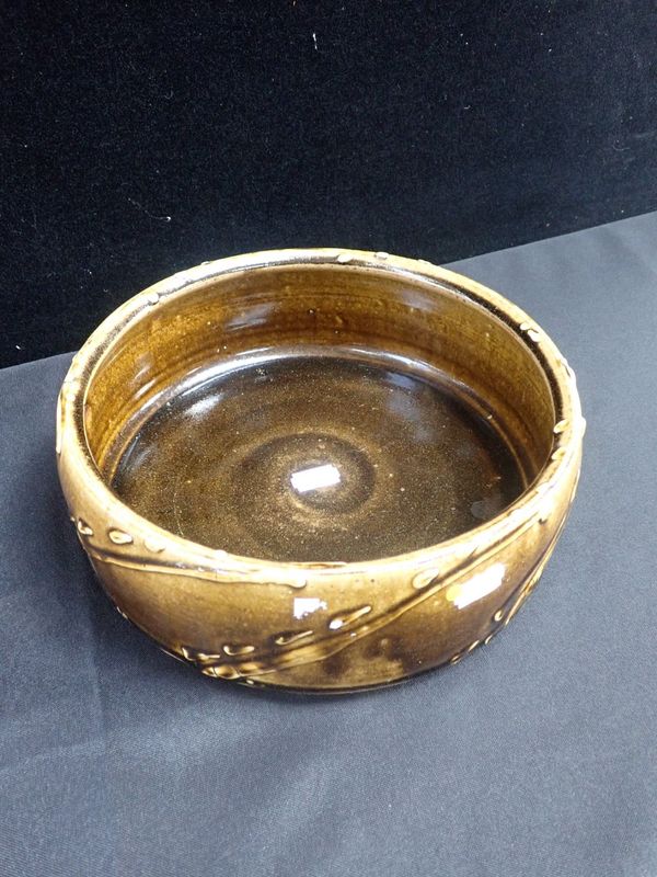 A JAPANESE BROWN-GLAZED POTTERY DISH