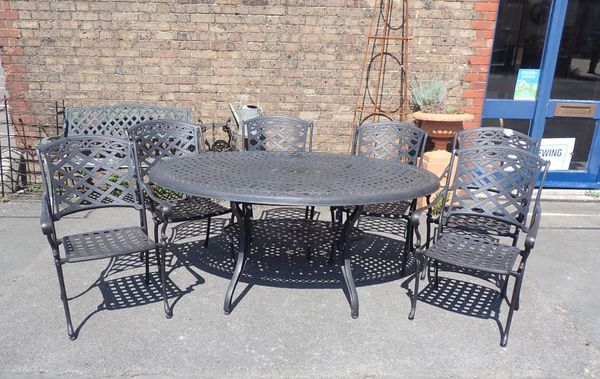 A CAST METAL OVAL GARDEN TABLE AND SIX CHAIRS
