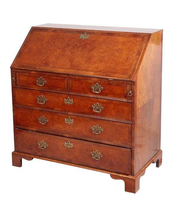 A WALNUT AND FEATHER BANDED BUREAU IN GEORGE II STYLE,