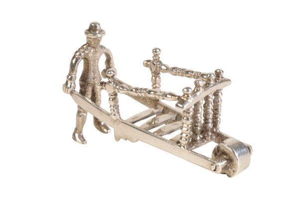 (now with line 112) A DUTCH SILVER MINIATURE OF A MAN PUSHING A WHEEL-BARROW