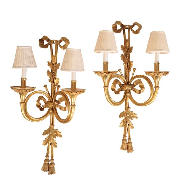 A PAIR OF SUBSTANTIAL GILT METAL TWIN LIGHT WALL APPLIQUES IN LOUIS XVI TASTE,