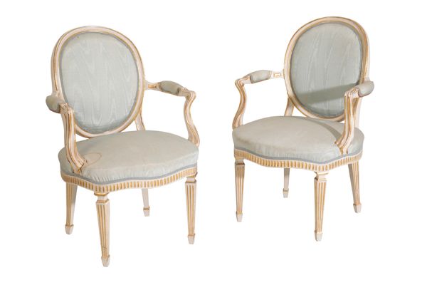 A PAIR OF CARVED, PAINTED AND PARCEL GILT FAUTEUILS IN LOUIS XVI STYLE,