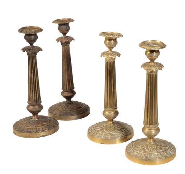 A MATCHED SET OF FOUR RESTAURATION GILT METAL CANDLESTICKS,