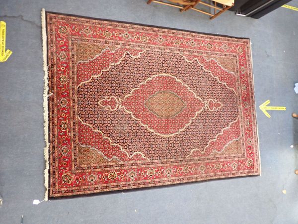A RED GROUND PERSIAN CARPET