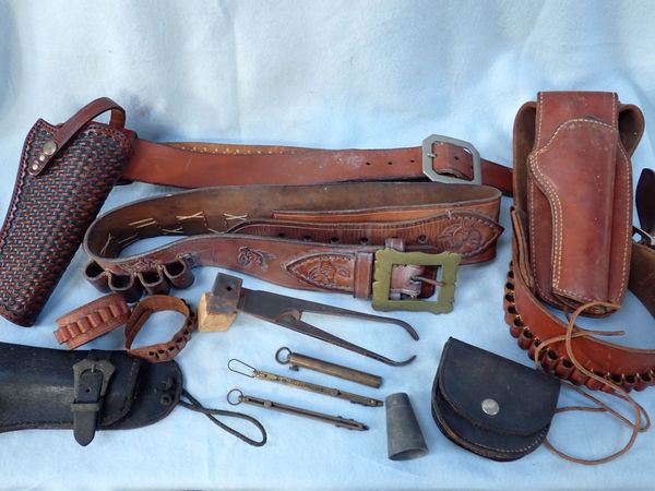 A COLLECTION OF AMMUNITION BELTS, HOLSTERS, A BULLET MOULD