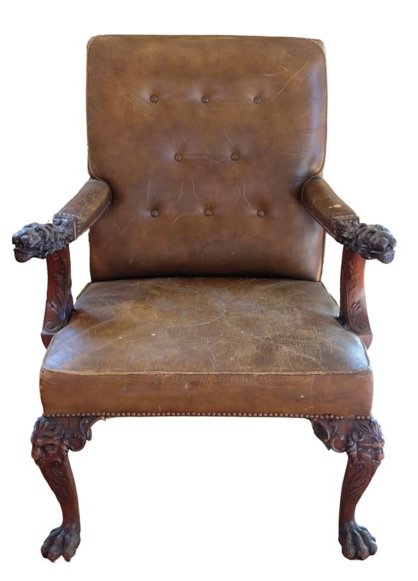 AN IMPRESSIVE GEORGE II STYLE CARVED MAHOGANY AND LEATHER UPHOLSTERED LIBRARY ARMCHAIR