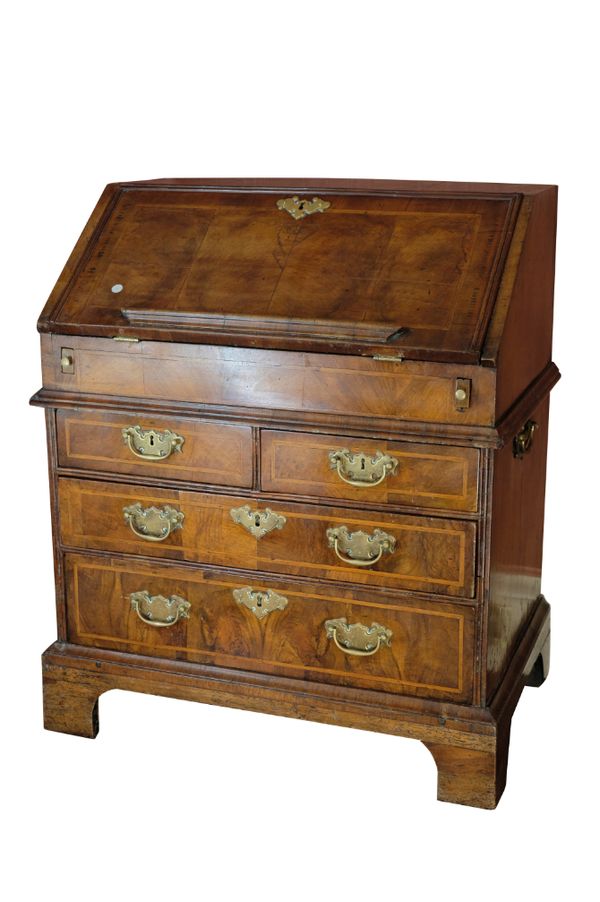 A GEORGE I WALNUT AND FEATHERBANDED BUREAU, CIRCA 1720