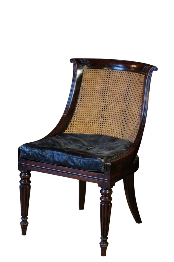 A LATE REGENCY MAHOGANY BERGERE LIBRARY CHAIR