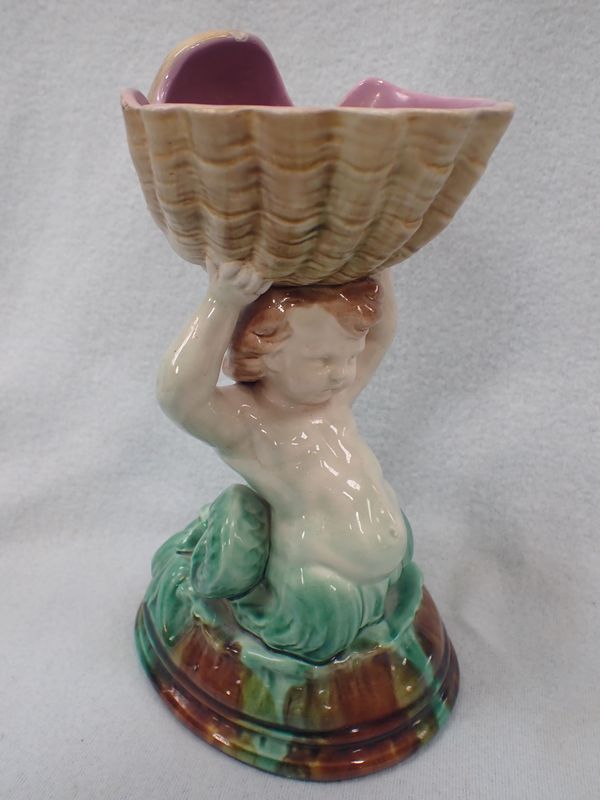 A MAJOLICA MERMAN HOLDING ALOFT A SHELL