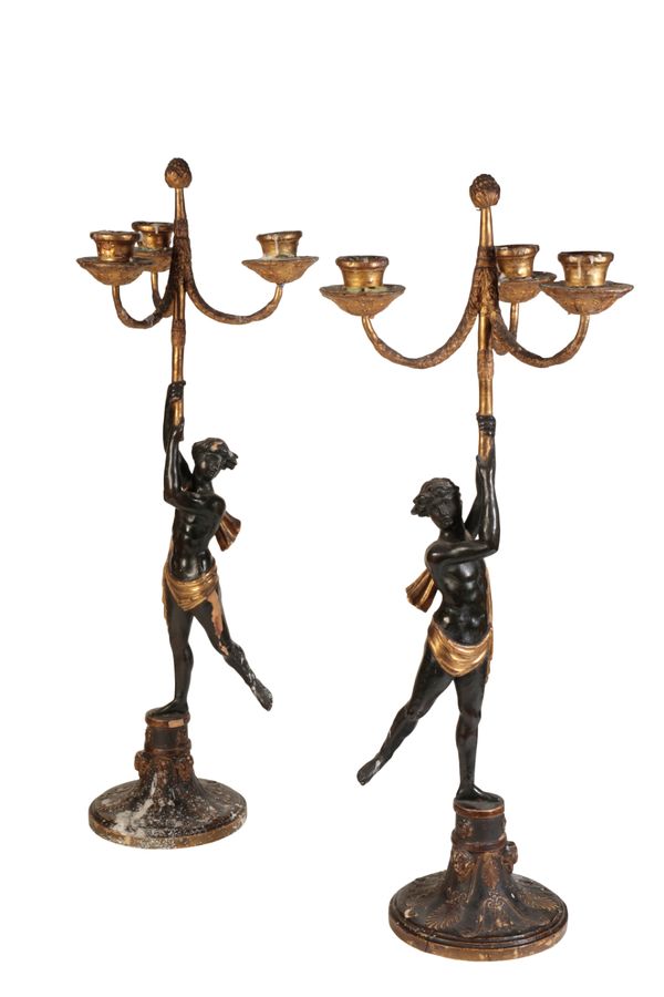 A PAIR OF ITALIAN CARVED, PAINTED AND PARCEL GILTWOOD AND COMPOSITION THREE LIGHT FIGURAL CANDELABRA,