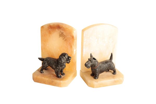 A PAIR OF CONTINENTAL PAINTED METAL MOUNTED ONYX BOOKENDS MODELLED WITH DOGS,