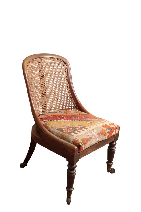 A REGENCY ROSEWOOD AND CANEWORK LIBRARY SLIPPER BERGERE, POSSIBLY BY GILLOWS,