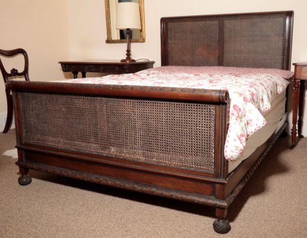 A CARVED MAHOGANY AND CANEWORK DOUBLE BED, BY HEAL & CO.,