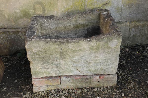 A ROUGH HEWN LIMESTONE TROUGH,