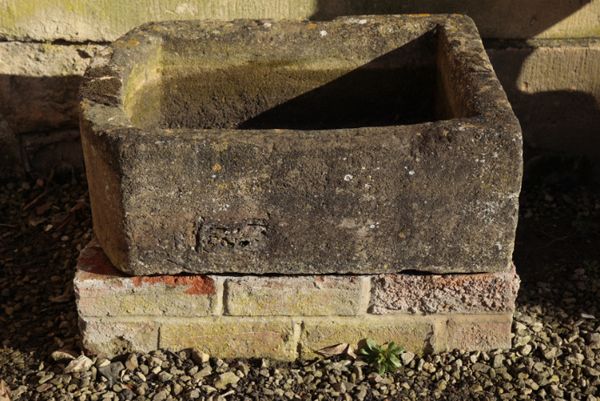 A ROUGH HEWN LIMESTONE TROUGH,