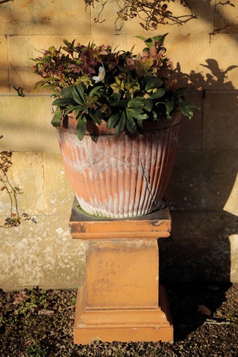 A PAIR OF TERRACOTTA GARDEN PLANTERS ON ASSOCIATED PLINTHS,