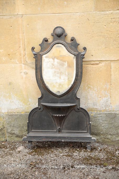 A LATE VICTORIAN OR EDWARDIAN PAINTED CAST IRON FRAMED WALL MIRROR,