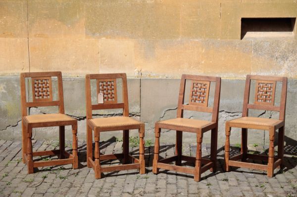 A SET OF FOUR CARVED OAK SIDE CHAIRS BY ROBERT 'MOUSEMAN' THOMPSON,