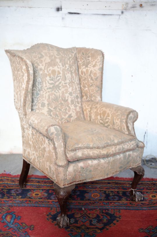 A VICTORIAN CARVED WALNUT AND UPHOLSTERED WINGBACK ARMCHAIR IN GEORGE I STYLE,