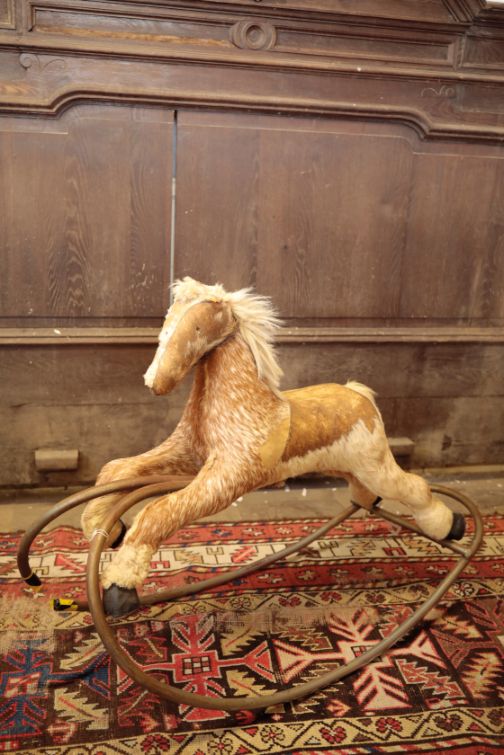 A HORSEHIDE COVERED ROCKING HORSE,