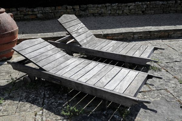 A SET OF FOUR SLATTED TEAK GARDEN RECLINERS,