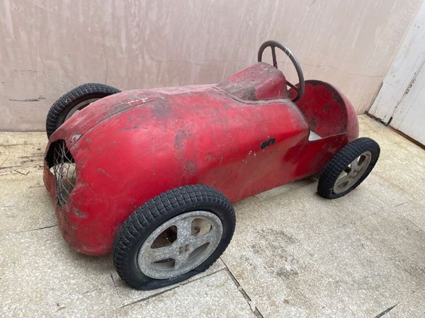 A CHILD'S PAINTED METAL PEDAL CAR MODELLED AS A RACING CAR,