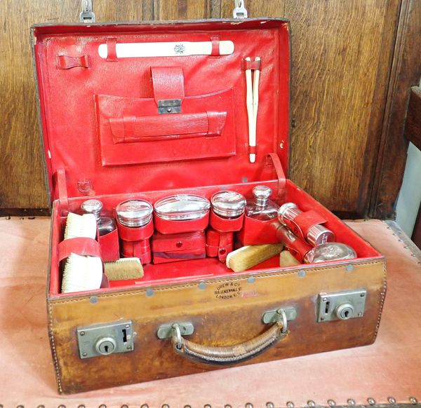 AN EDWARDIAN LEATHER DRESSING CASE WITH SILVER-TOPPED JARS