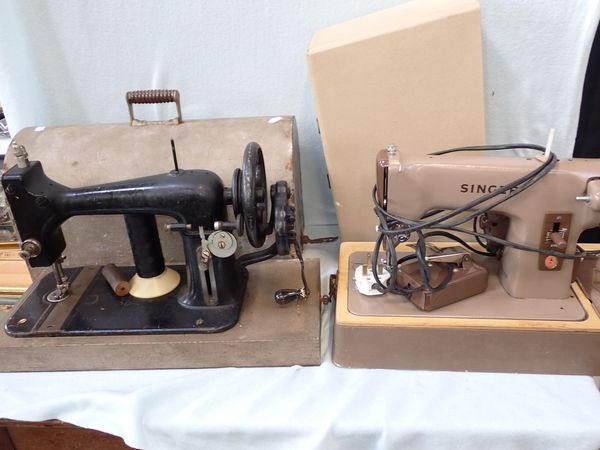 A VINTAGE SEWING MACHINE WITH METAL CASE