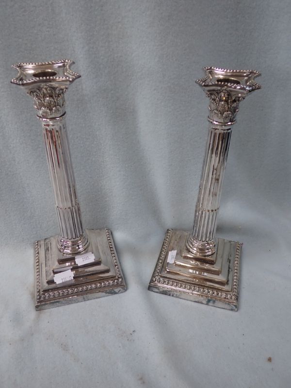 A PAIR OF SILVER PLATED CORINTHIAN COLUMN CANDLESTICKS