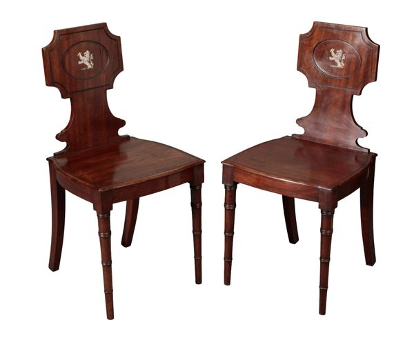 A PAIR OF GEORGE III MAHOGANY ARMORIAL HALL CHAIRS