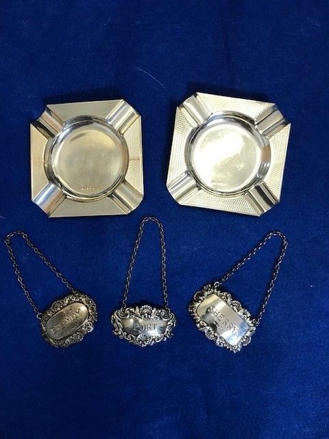 THREE SILVER WINE LABELS AND A PAIR OF SILVER ASHTRAYS