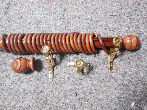 A LONG VICTORIAN STYLE STAINED PINE CURTAIN POLE