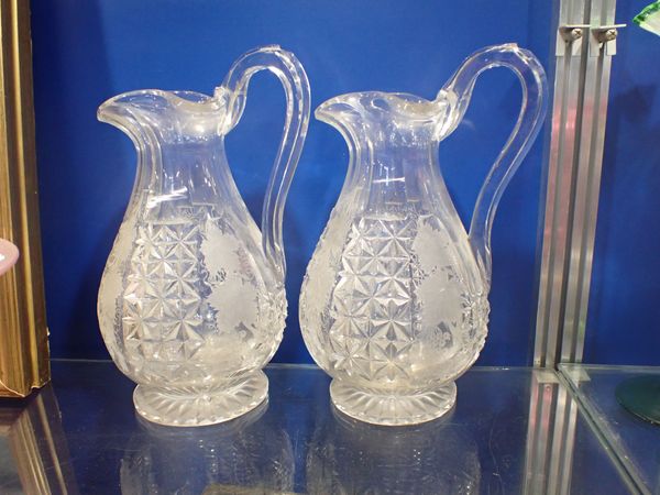 A PAIR OF 19TH CENTURY HEAVY CUT GLASS JUGS