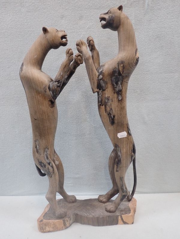 A CARVED HARDWOOD SCULPTURE OF TWO LEOPARDS FIGHTING
