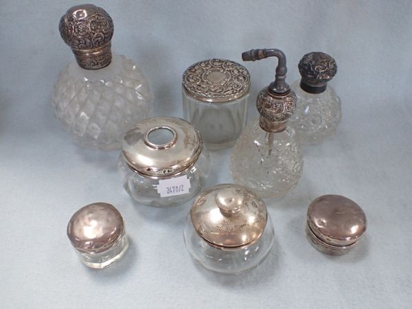 A COLLECTION OF CUT-GLASS SILVER TOPPED BOTTLES AND JARS (8)