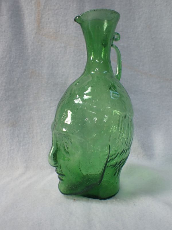 A GREEN GLASS JUG, BLOWN IN THE FORM OF A HEAD