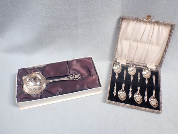 A SILVER TEA STRAINER WITH PIERCED HANDLE