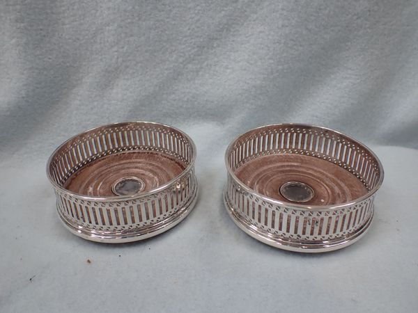 A PAIR OF SILVER BOTTLE COASTERS