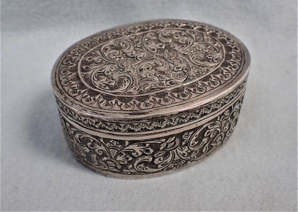 AN INDIAN WHITE METAL OVAL BOX