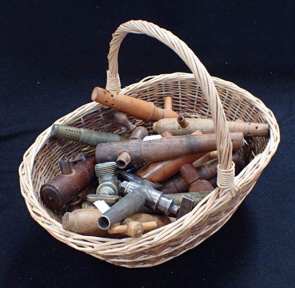 A BASKET OF WOODEN AND BRASS BARREL PEGS