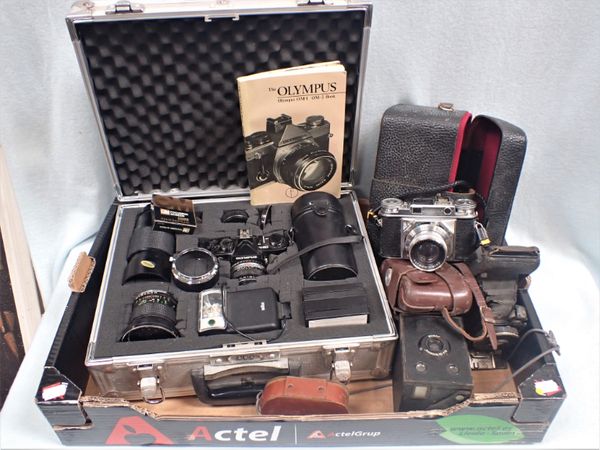 AN OLYMPUS OM-1 CAMERA, CASED WITH ACCESSORIES