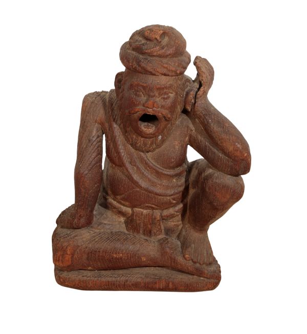 A CARVED WOOD FIGURE OF A SITTING MAN