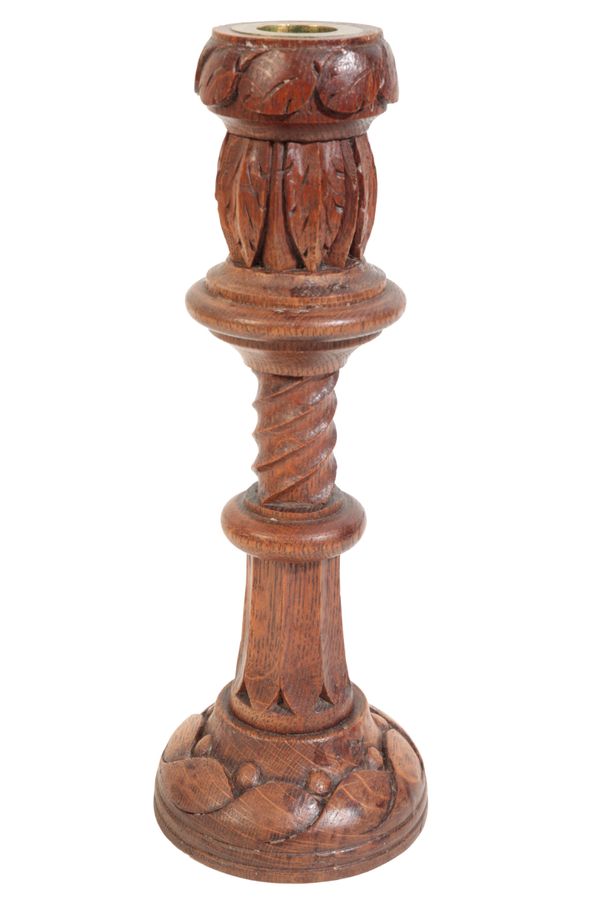 AN ARTS AND CRAFTS CARVED OAK CANDLESTICK