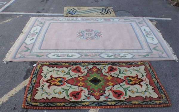 A LARGE PINK CHINESE RUG AND TWO WOOLEN RUGS