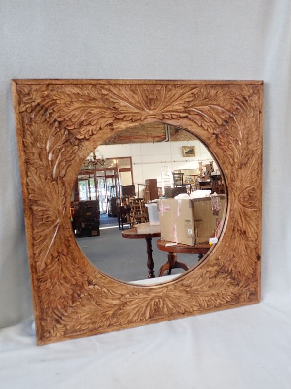 A CIRCULAR MIRROR, IN A CARVED HARDWOOD FRAME