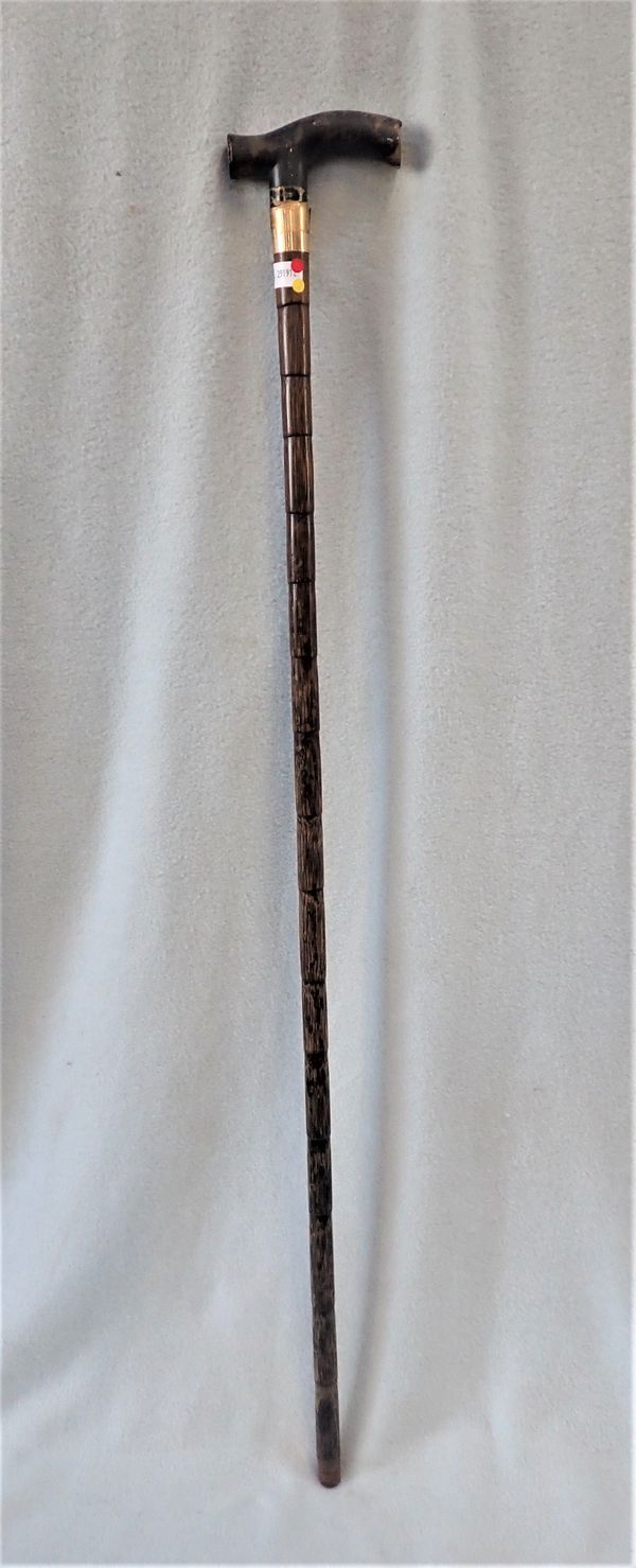 A WALKING STICK WITH A GOLD COLLAR