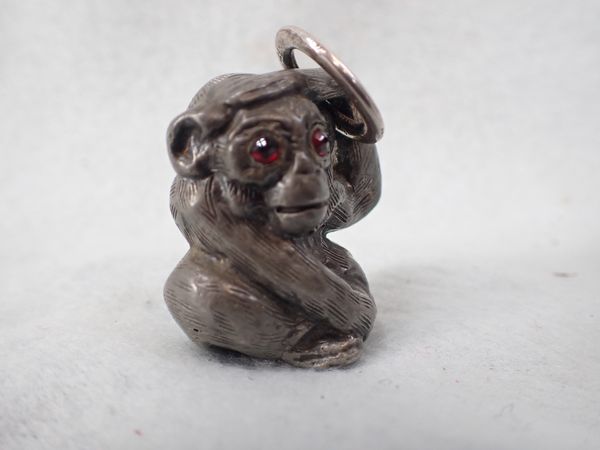 A CAST METAL MONKEY, POSSIBLY JAPANESE, WITH 'GARNET' EYES